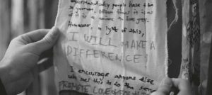 Background Image: hands holding a fabric hand-written sign reading "I will make a difference"