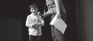 Background Image: Boy being asked a question on stage