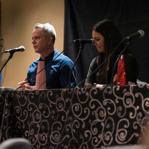Ayesha Barmania, David Curtis and Megan Murphy speaking at a table of panelists