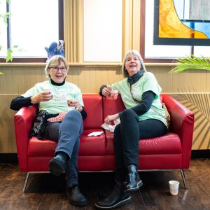 ReFrame volunteers seated on a red sofa taking a much-deserved break