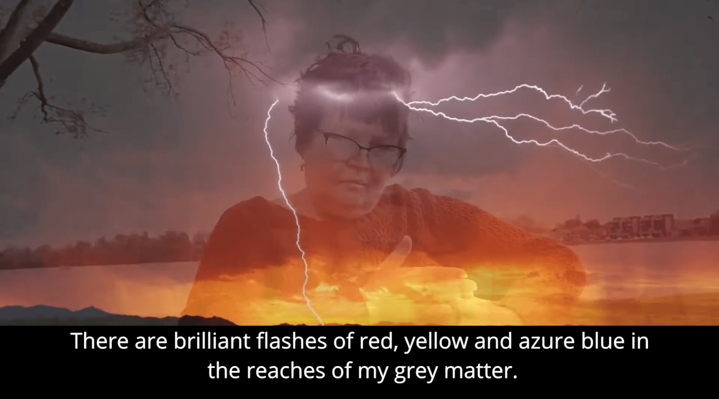 The image is a composite with a layered visual effect. In the foreground, there is a semi-transparent overlay of a person's head and upper torso. The person has short hair, wears glasses, and is looking slightly to the right. The background is a dramatic scene with a fiery explosion near the bottom and lightning in the upper right corner against a dark, stormy sky. Overlaid text at the bottom of the image reads: "There are brilliant flashes of red, yellow and azure blue in the reaches of my grey matter." The overall effect is surreal, suggesting a dynamic and possibly tumultuous inner state.